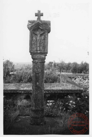 Bildstock situé au 85 avenue de Nieppe à Basse-Ham. Appelée "Croix du pont de la Bibiche", elle était dressée, jusqu'au début du XXe siècle, sous un arbre dit "de la Liberté", sur la rive opposée de la Bibiche. Cette situation l'a fait considérer comme "croix de justice" ou "croix de franchise". La niche avant abrite une scène de crucifixion, une autre Sainte-Claire et ..., ensuite Saint-Nicolas et Saint-Jude puis Saint-Pierre et Saint-Willibrord. Les attributs professionnels sculptés sur le fût sont ceux de l'agriculteur : le coutre et le soc de la charrue