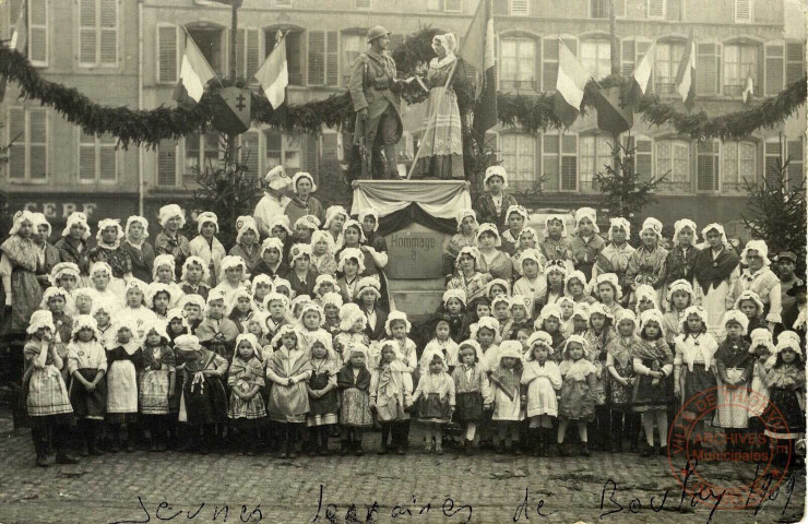 [Vues de défilés de troupes françaises dans les rues de Boulay - jeunes filles en costume lorrain sur une place de Boulay]