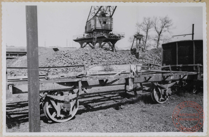 Wagon à décombres dont il ne reste que le châssis.