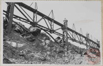 Parc à scories. Un aspect de la charpente dans la partie médiane. Scories pêle-mêle avec une énorme proportion de riquettes. Poteaux enlisés, arcs-boutants pliés.