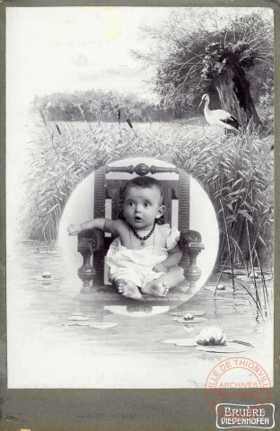 Portrait de Pierre, 7 mois, il est entouré d'un décor représentant un paysage marécageux et une cigogne