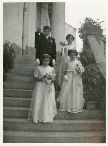 4 communiants posent pour la photo. Au dos est écrit "la première est ma fille Odile, les autres sont les enfants de Robert"