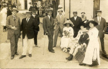 [Photographie d'un groupe de personnes endimanchées posant dans une rue en 1912]