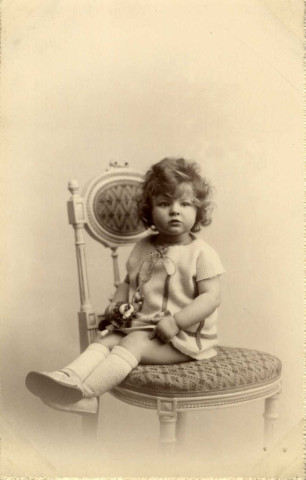 [Photographie d'une jeune fille assise sur une chaise]