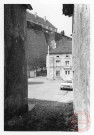 Vue depuis la ruelle au fond de la place de la Fontaine à Rodemack. Au fond la maison au 65 place de la Fontaine , puis le mur d'enceinte du château