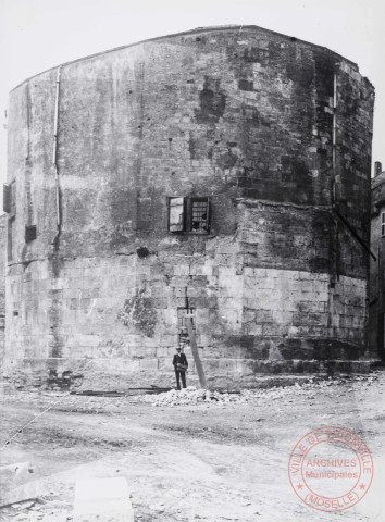 [Un homme posant devant la Tour aux Puces]