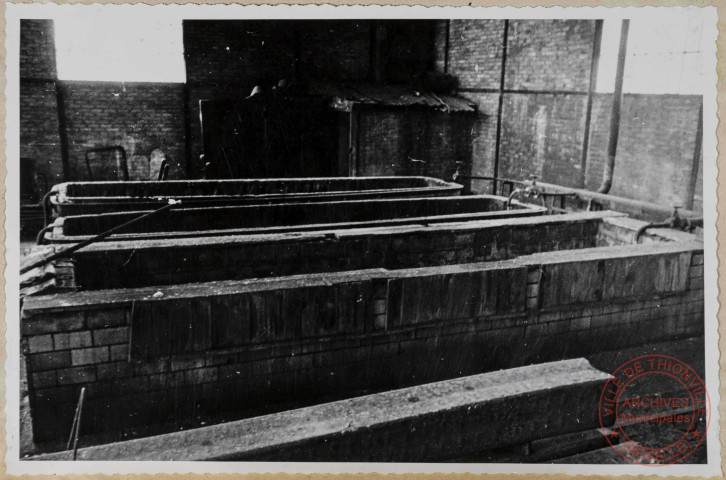 Halle 15. Bacs de décapage. On remarque un coffrage en planches pour maintenir les briques corrodées.