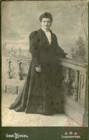 Portrait d'une femme en robe noire se tenant à un parapet