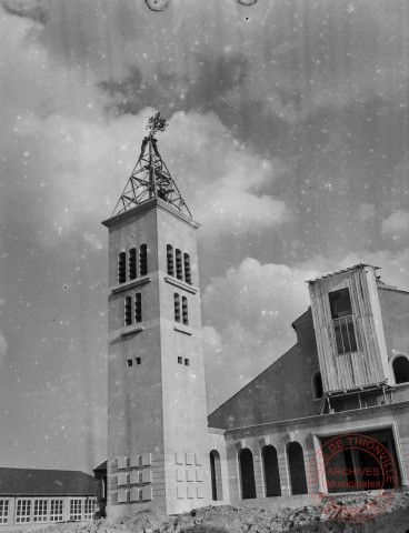 [Eglise Notre-Dame de l'Assomption, à l' intérieur un christ sur sa croix et à l'extérieur, finition de la charpente du clocher avec le bouquet final posé sur le point culminant]