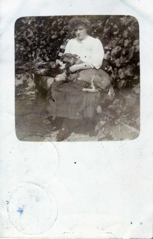 [Photographie d'une amie d'Yvonne Hourte avec un chien sur ses genoux en Belgique en 1910]
