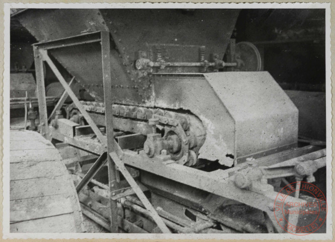 Distributeur à charbon sous le silo; Photographie montrant l'usure du distributeur à chaînes sans fin des convoyeurs à godets; Les tôles de la partie basse des trémies sont à remplacer.