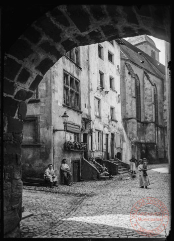 [Sierck-les-Bains, la rue de la tour de l'Horloge et l'église au fond. Photo prise sous l'arche de la tour]