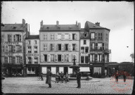 [La place du Marché. De gauche à droite, photographie Bruère, Au Bon Marché A. Lesceux, Café]