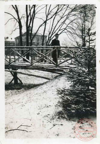 Portrait d'un homme posant sur un petit pont en bois dans un parc