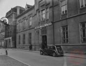 [Commissariat central de police, rue du Vieux Collège, au fond à gauche le café de la Cigogne]