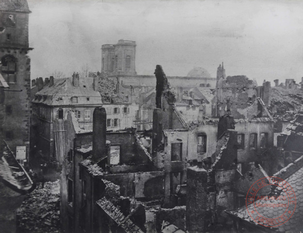 [Coin de la rue Neuve et de la rue de Paris après les bombardement de 1870. Dans le fond l'église Saint-Maximin]