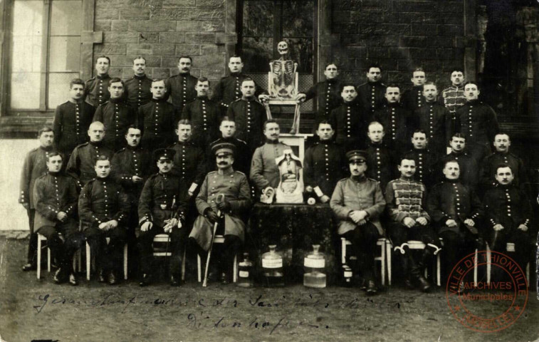 [Photographie de soldats allemands posant avec un squelette, une coupe de tronc humain et des bocaux, dans les années 1900]