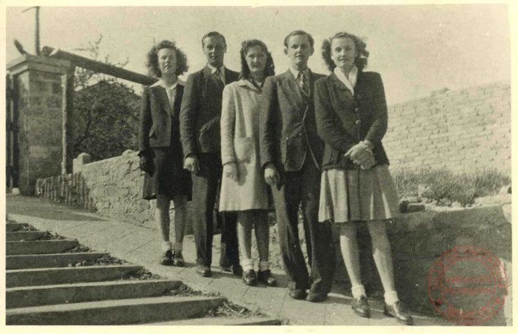 5 jeunes hommes et femmes posent dans une desscente de garage