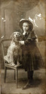 [Portrait d'une jeune fille avec son chien assis sur une chaise dans les années 1900]
