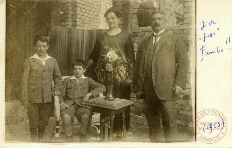 [Famille avec deux enfants posant à l'extérieur, apparemment en 1923]