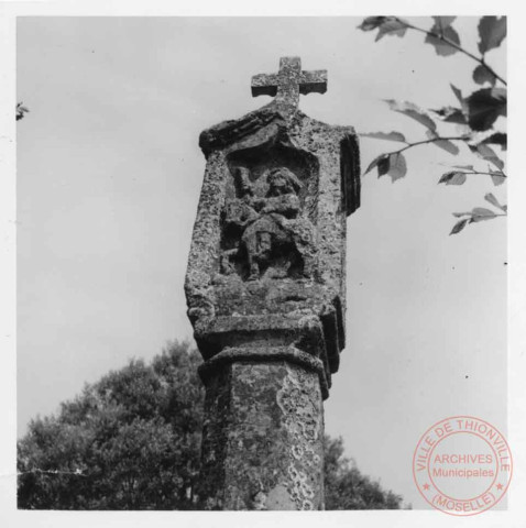 Bildstock appelé "Croix de la Millewee", situé rue Théodore de Puymaigre, à côté du terrain de tennis à Inglange. La crucifixion met en scène la Vierge et Saint-Jean. Au-dessous, les reliefs représentant Siant-Hubert, Saint-Nicolas et Saint-Pierre.