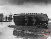 Soldats américains mettant à l'eau une barque d'assaut pour passer la Moselle en crue, près de Cattenom, en novembre 1944