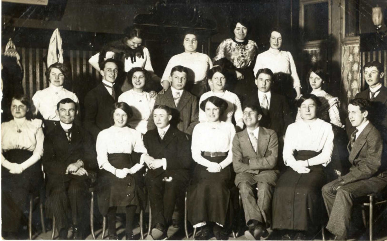 [Photographie d'un groupe de jeunes posant dans une pièce de maison en 1912]