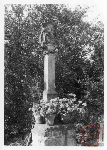 Bildstock situé contre le mur Est de l'église Saint-Denis de Roussy-le-Village. Croix érigée en 1548 (date portée à la base de la face antérieure de l'édicule) à Soetrich (commune de Hettange-Grande, Moselle) en bordure de la R.N. 53 à la sortie nord du village à droite. Erigée à son emplacement actuel en 1974 par l'abbé Alex Pax, curé de Roussy