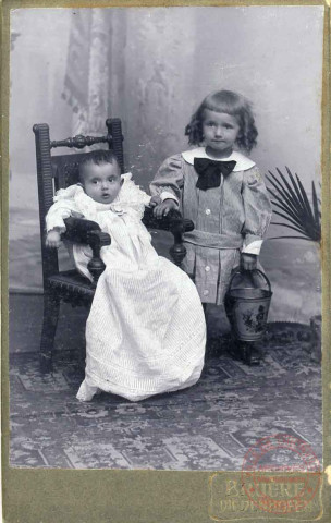 Portrait de Pierre, 7 mois et Louis, 3 ans, l'un sur une chaise et l'autre tenant un petit seau