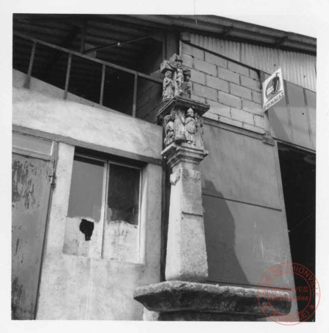 Bildstock situé contre le bâtiment 5 rue Principale à Inglange, stèle représentant le Christ en croix accoté de la Vierge et de saint Jean, d'autres personnages en relief juste au-dessous.