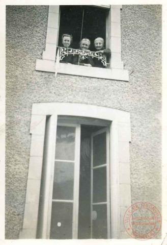 3 dames posent à la fenêtre du premier étage