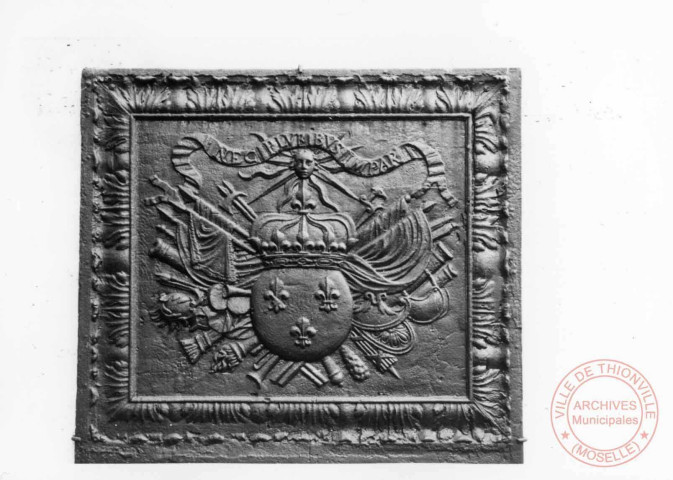 Plaque de cheminée : les armes de France, XVIIe située sur la façade de l'église Saint-Denis de Roussy-le-Village. Transcription sur la plaque : NEC PLVBIBVS IMPAR