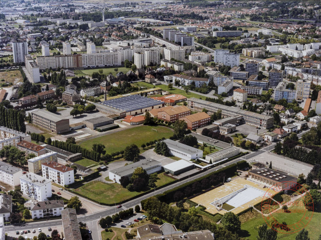 Vue aérienne de Thionville - Au premier plan la piscine municipale, suivi de l'ancien collège "Paul Valéry" puis du lycée "La Briquerie". On aperçoit au fond la caserne des pompiers et à droite le stade de Guentrange