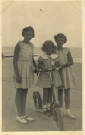 [Photographie de jeunes filles à la plage dont l'une a une trotinette]