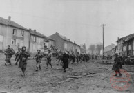 Le froid et la boue dans le village de Metzervisse. Des hommes du 358e RI US partent sur Thionville, où ils seront placés en réserve. Ils sont suivis de quelques chars Sherman qui doivent effectuer une halte. Novembre 1944