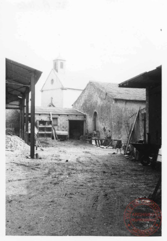 Ferme située au 1 rue de la Fontaine à Cattenom, au fond la chapelle du cimetière