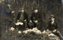 [Photographie d'un groupe de chasseurs avec le garde-chasse à la pause déjeuner lors de la Saint-Hubert de 1930]