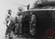 Trois tankistes du 712e bataillon de chars, rattaché à la 90e DI US, montrent comment ce Sherman a été détruit par un Panzerschreck (équivalent allemand du bazooka), alors qu'il entrait le premier dans le village de Metzervisse en novembre 1944