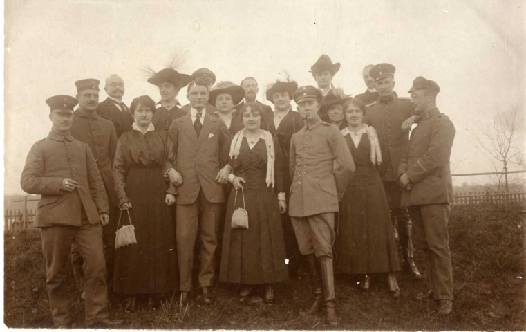 [Photographie prise dans la campagne d'un groupe de ciivils et de militaires dans les années 1910]