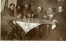 [Photographie de soldats en uniformes allemands avec un prêtre autour d'une table avec des chopes de bière en 1914]