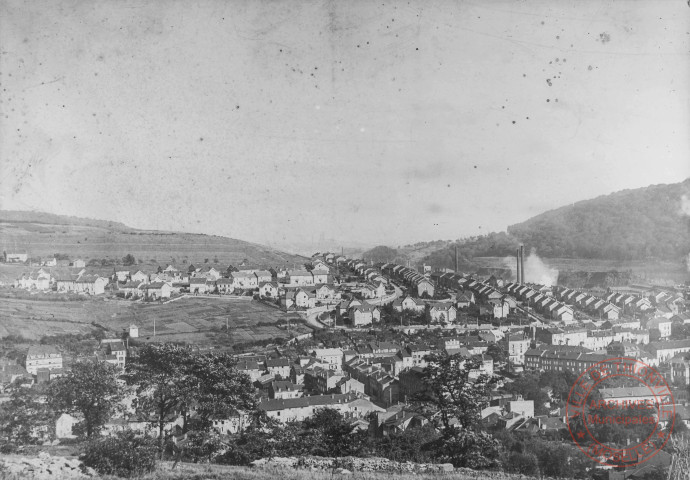 Vue panoramique de Moyeuvre-Grande et de l'usine sidérurgique, au milieu l'église Saint-Gorgon et à droite l'église protestante et la place de la République