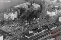 [Vue aérienne de la place de la Gare dans les années 1970, avec la gare, le centre Jacques Brel, la maison des associations Raymond Queneau]