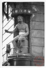 Statue représentant un homme assis sur un ballot de tabac, située à l'angle de la rue des Deux-Places et de la rue du Four Banal à Thionville