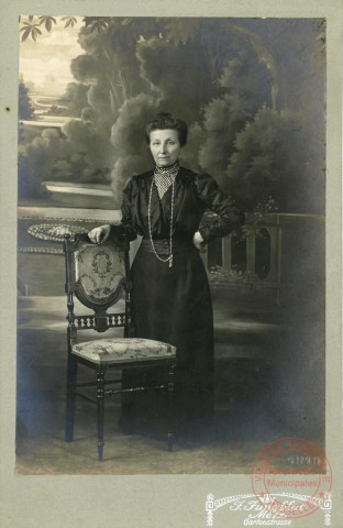Portrait d'une femme en studio, accoudée à une chaise
