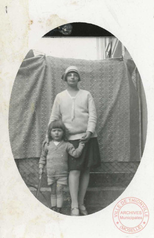 1 femme et 1 enfant posent dans une cour