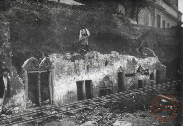 Le démantèlement des fortifications de Thionville (1902-1903). Découverte du quartier médiéval de Thionville entre l'église Saint-Maximin et la Moselle lors des travaux de démolition des fortifications. Ici, une façade XIIIe siècle(la porte) avec des éléments du XIVe siècle. Notons que la niveau médiéval était beaucoup plus bas que l'actuel niveau de la ville. Ce quartier fut enterré, à partir du XVe siècle pour assurer un puissant rempart sur la Moselle. 1902