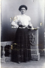 [Photographie d'une jeune femme posant chez un photographe, dans les années 1900]