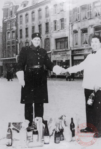 [Un policier pose avec un serveur place du Marché à Thionville]