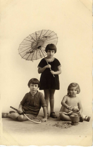 [Photographie de jeunes filles avec ombrelle, raquette et seau de plage]