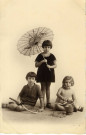 [Photographie de jeunes filles avec ombrelle, raquette et seau de plage]